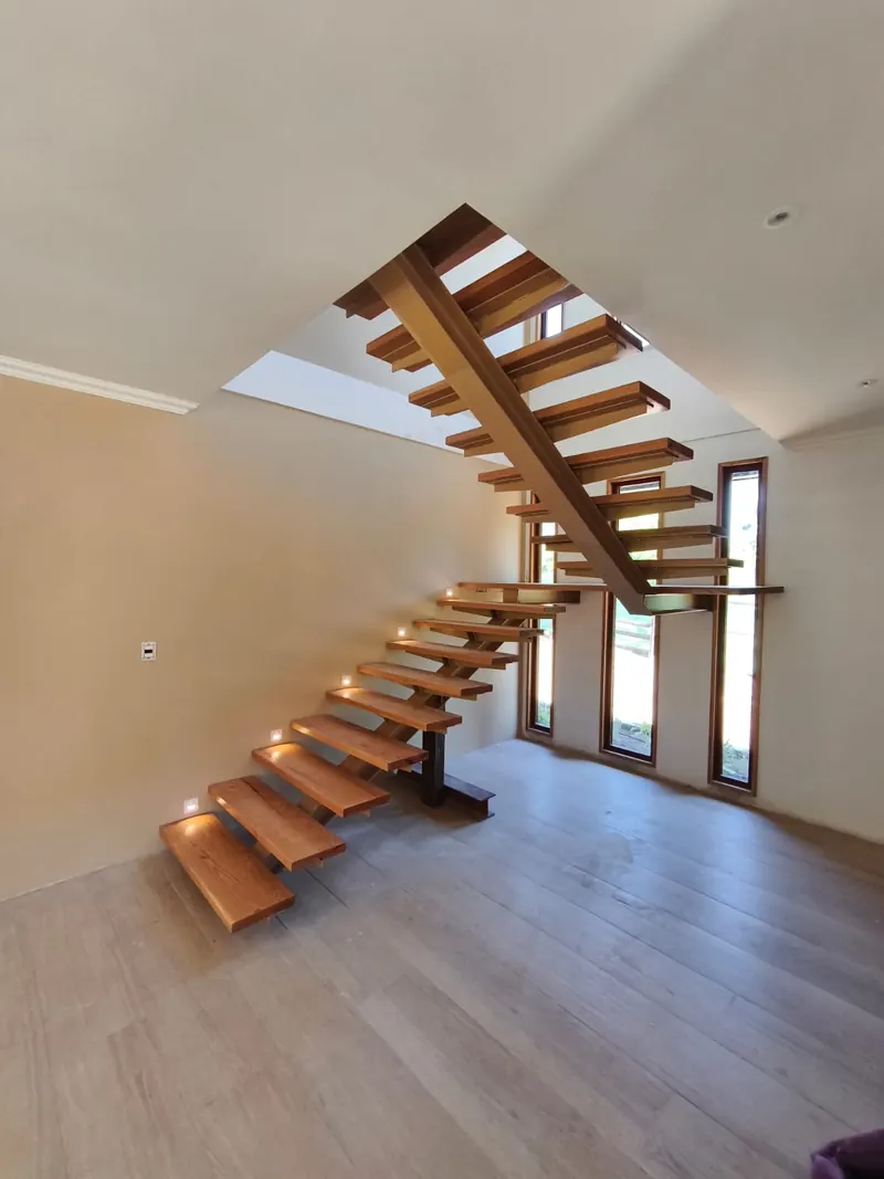 Escalera de peldaños de madera con luces de paso en el muro